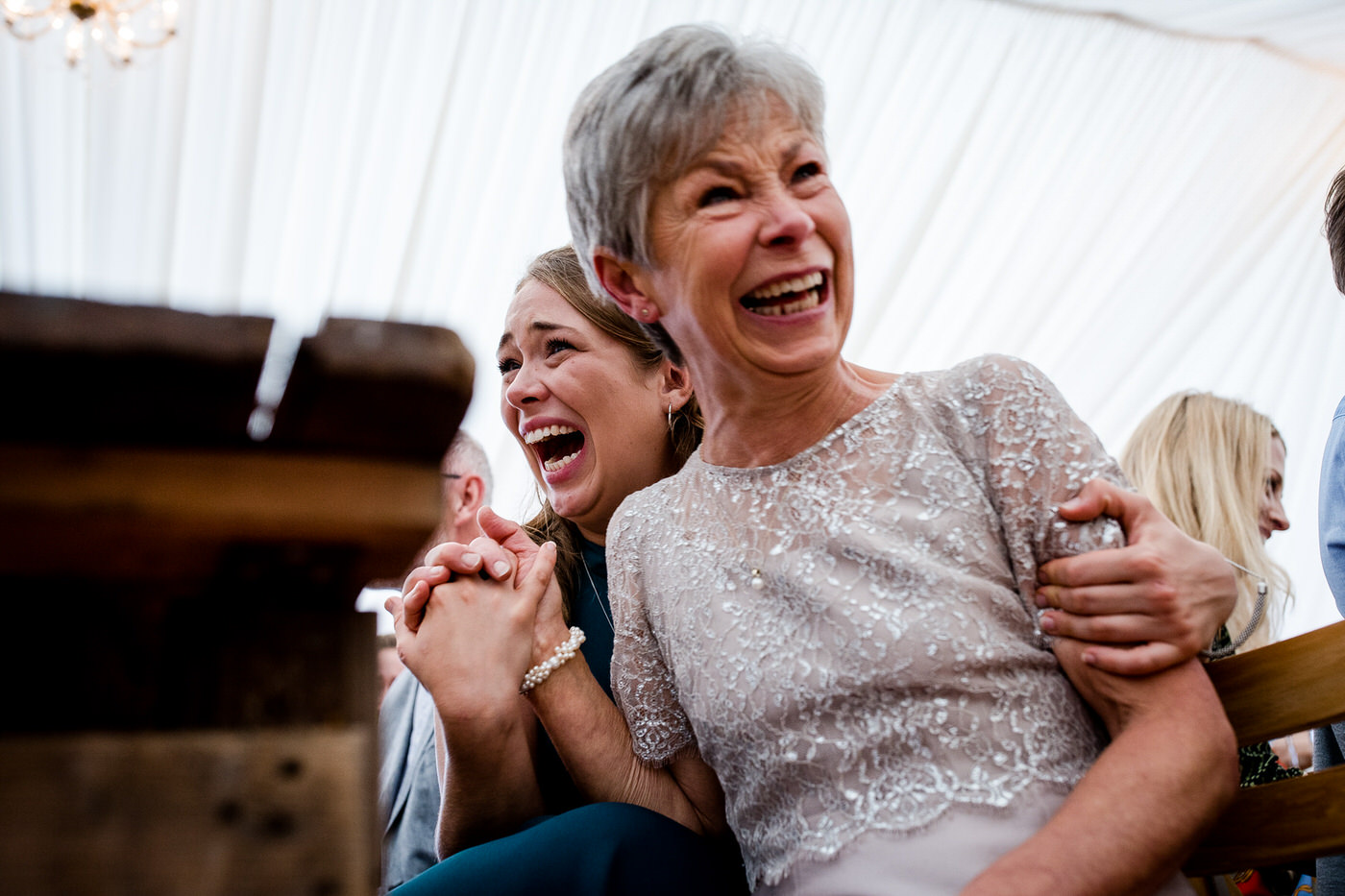 Wedding guests laughing and holding hands during an emotional and joyful ceremony moment at a Bristol wedding