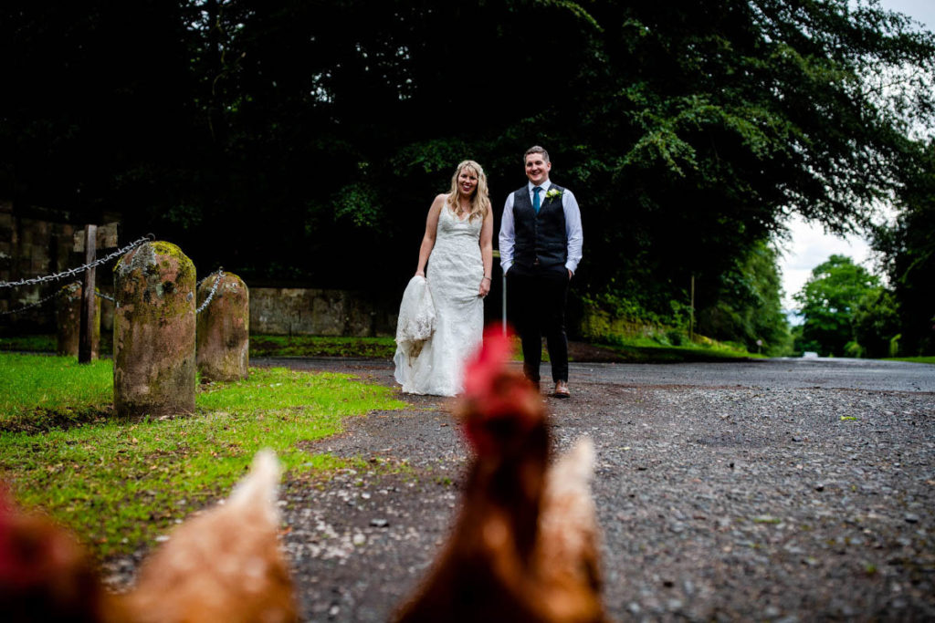 Bride and groom with chickens at High Barn Wedding - Edenhall Estate