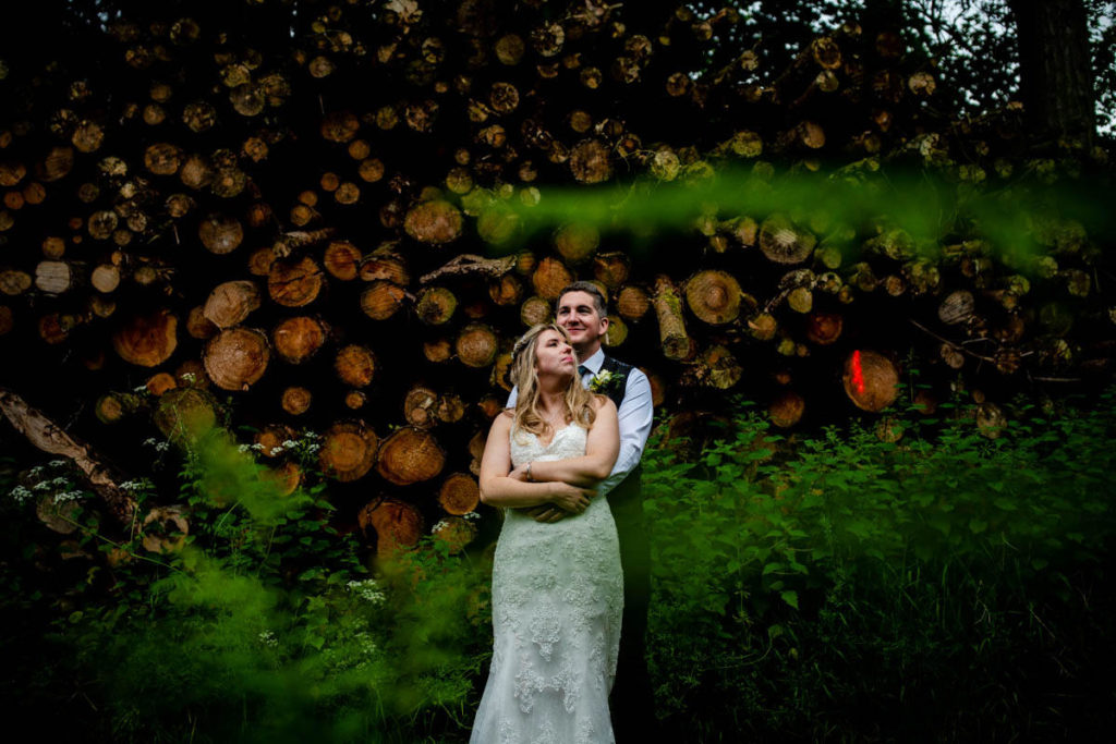 Bride and groom awkward wedding photo with logs // High Barn Wedding - Edenhall Estate