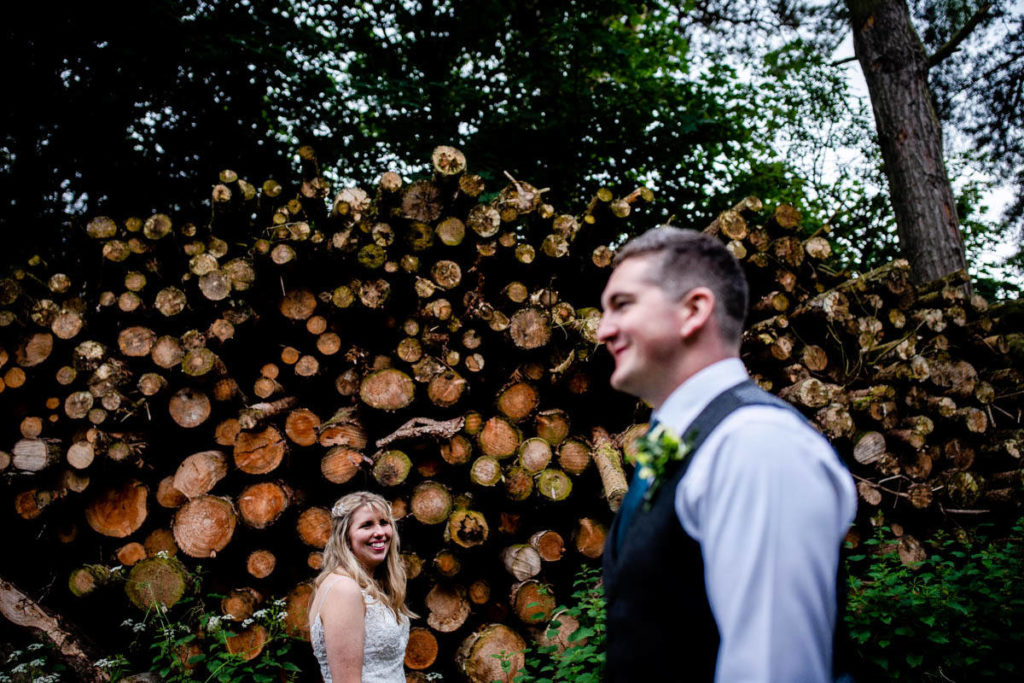 Bride and groom wedding photo with logs High Barn Wedding - Edenhall Estate