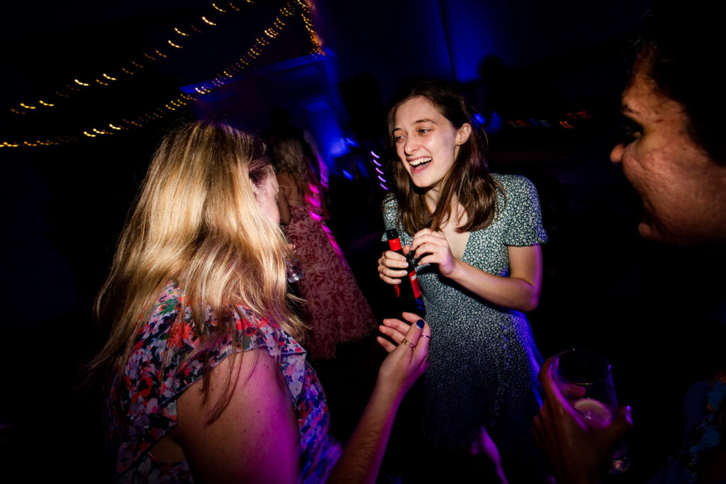 a woman laugh on the dancefloor holding a beer
