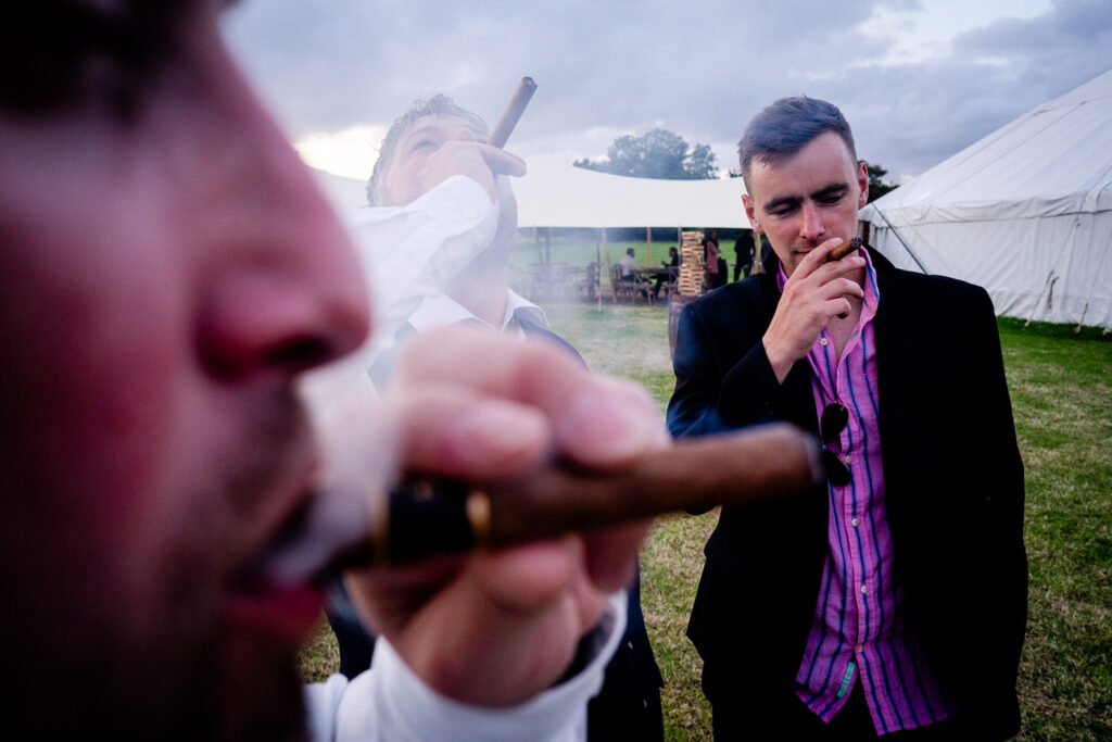 groom and groomsmen smoking cigars outside the yurt at leyfold events.